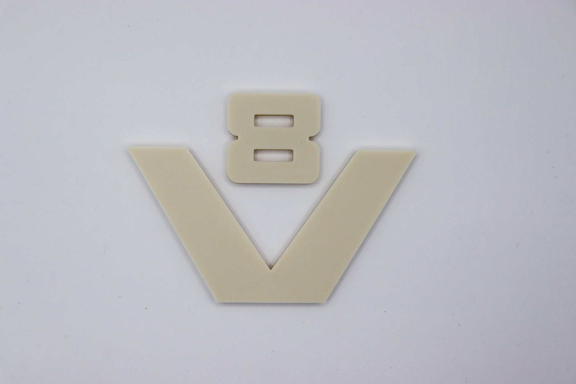 dit is een oldskool v8 logo van scania net zoals bij de 1 2 & 3 serie, dit logo is de zelfde grootte als het v8 logo wat nu op de side skirt van de next gen zit. het is in een blanco beige kleur geprint zodat het naar eigen wens in de juiste kleur gespoten kan worden.